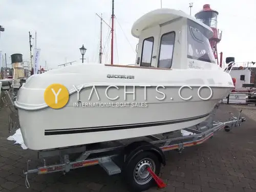 Quicksilver 500 Pilothouse: port side of white hull with wheelhouse on a road trailer, lightship behind on quayside
