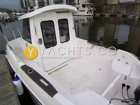 Quicksilver 500 Pilothouse: aft deck with wooden rails, rod holders, rear seating and the pilothouse doors