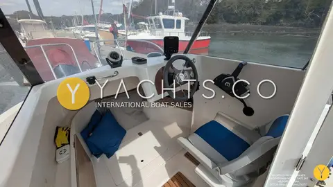 Quicksilver 500 Pilothouse: pilothouse interior with helm seat, blue cushions, steering wheel and throttle control