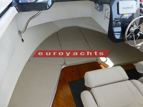 Quicksilver 605 Pilothouse: forward cabin V-shaped cream cushions forming berths, with wooden floor below
