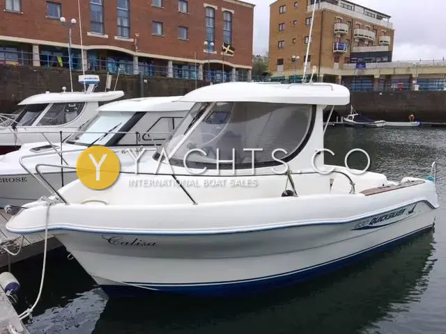 Quicksilver 630 SD *diesel*: white wheelhouse fishing boat moored at a marina pontoon beside brick apartment buildings