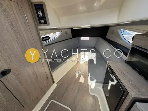 Quicksilver 875 Sundeck: cabin interior with grey wraparound dinette seating, side windows and light wood-effect floor