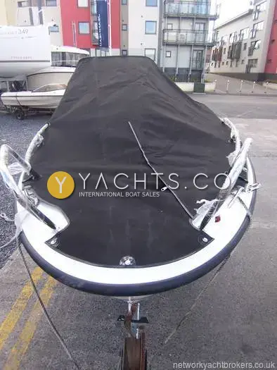 Quicksilver Activ 455: bow view on trailer with black full boat cover fitted, apartments behind