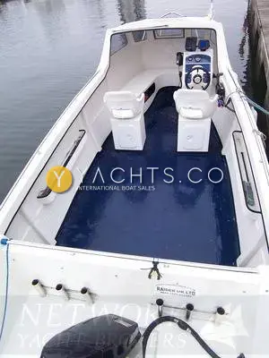 Raider 18: view forward over the transom into the open blue-floored cockpit, twin helm seats and wheelhouse