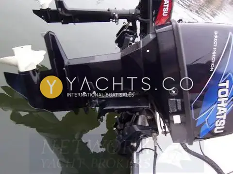 Raider 18: side view of the 90hp direct injection outboard tilted up, with the auxiliary engine behind