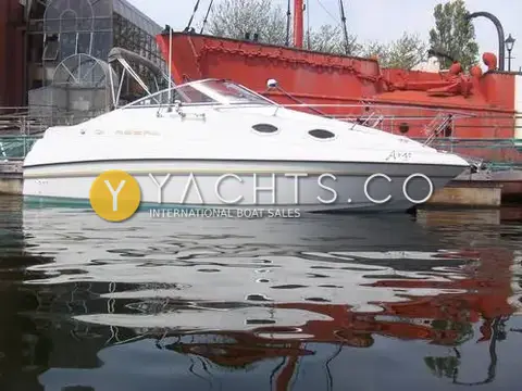 Regal 242 Commodore: starboard profile showing hull name on the bow, red lightship in the background