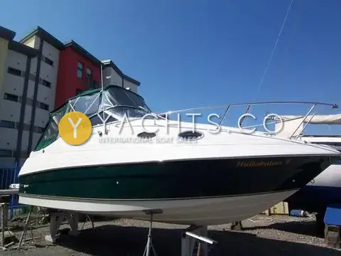 Regal 2460 Commodore: bow quarter view ashore, white hull with dark green topsides and green canopy fitted