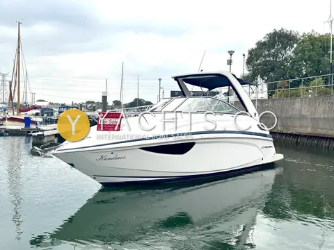 Regal 28 Express: starboard bow view of the white hull and arch alongside a marina pontoon