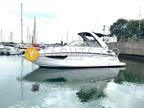 Regal 28 Express: starboard side profile showing hull windows and arch in a marina basin