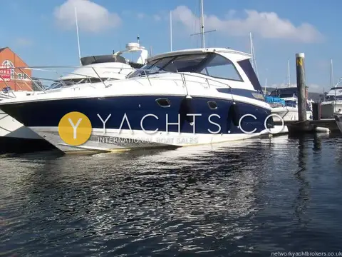 Regal 35 Sports Cruiser: port side profile showing navy blue hull and fenders out in a marina berth