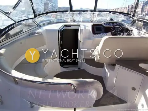 Regal 3760: cockpit seating wrapping around to the helm, with grey carpet and wet bar unit