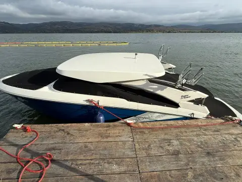 Regal LS4 Surf: bow view moored at a wooden pontoon, showing the hardtop and tower-mounted board racks