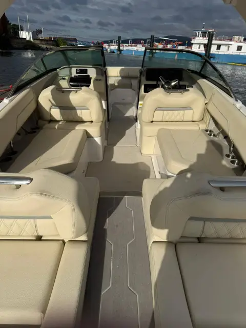 Regal LS4 Surf: cockpit looking forward, cream upholstered seating, twin helm seats and grey non-slip decking