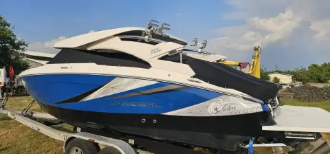 Regal LS4 Surf: starboard side on a road trailer, showing blue and white hull graphics and wakeboard tower