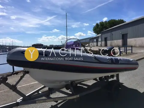 Ribeye 400: bow view on trailer at the quayside with purple-tinted windscreen and outboard behind