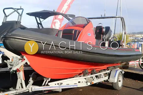 Ribquest 6.3: red hull and black tubes on a single axle road trailer, viewed from the bow quarter