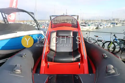 Ribquest 6.3: black and red upholstered forward console seat with windscreen ahead, marina behind