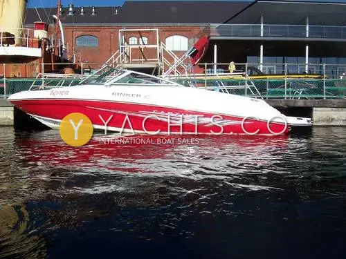 Rinker 192 Reduced: port side of the red and white hull moored alongside a brick dockside building