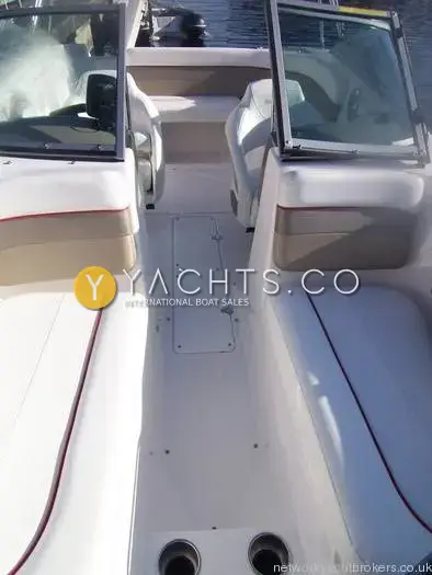 Rinker 192 Reduced: walk-through windscreen looking aft over the cockpit floor and white seating