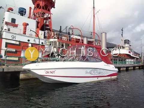 Rinker 210 MTX: port side view with camper cover fitted, moored beside a red and white lightship