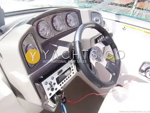 Rinker 210 MTX: helm dashboard with white-faced gauges, leather-trimmed wheel and stereo below the panel