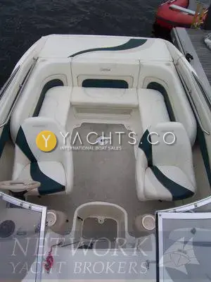 Rinker 232: cockpit from above with cream and green helm seats, U-shaped rear seating and grey carpet