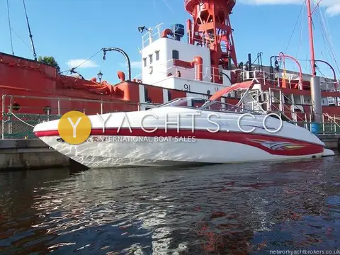 Rinker 232: white hull with red stripe moored alongside a red lightship in the marina