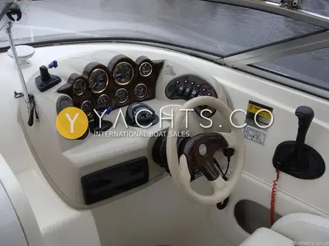 Rinker 232: close view of helm with burr-effect gauge cluster, compass and switch panel