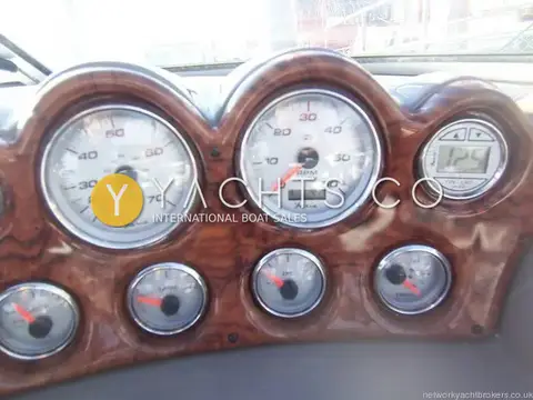 Rinker 232: helm gauges in burr wood-effect dash, including speedometer, rev counter and depth display