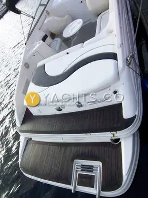 Rinker 232: aft view from above of the sunpad, transom controls and teak-laid bathing platform with boarding ladder