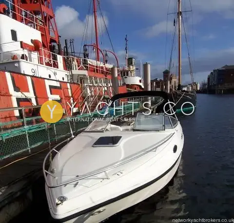 Rinker 232: foredeck and windscreen seen from the bow, alongside a red lightship and tall ship