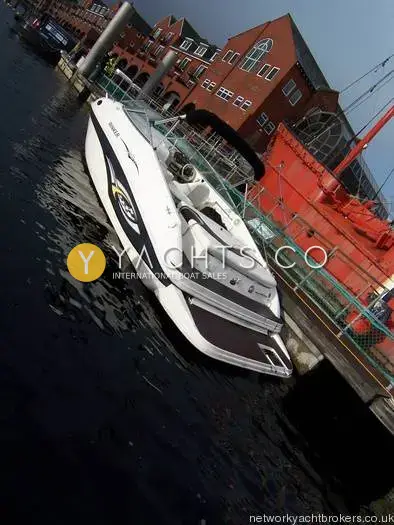 Rinker 232: high stern view showing black graphics, Bimini frame and bathing platform at a pontoon