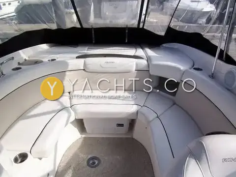 Rinker 246: aft cockpit with U-shaped cream lounge seating, sunpad behind and carpeted floor
