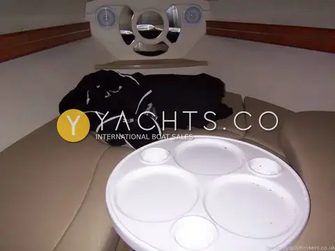Rinker 246: forward cabin V-berth with round white table, cup holders and twin speakers