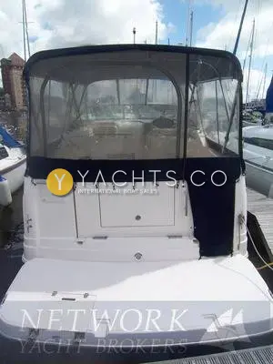Rinker 270 Reduced: stern view with navy camper cover enclosing the cockpit and extended bathing platform