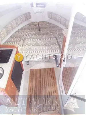 Rinker 270 Reduced: forward cabin berth with patterned upholstery, teak cabin sole and galley edge