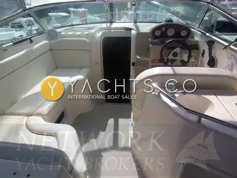 Rinker 270 Reduced: cockpit with cream seating, cabin door and helm console under the windscreen