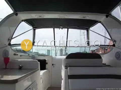 Rinker 280: cockpit under full canopy, looking forward to windscreen with wet bar and seating