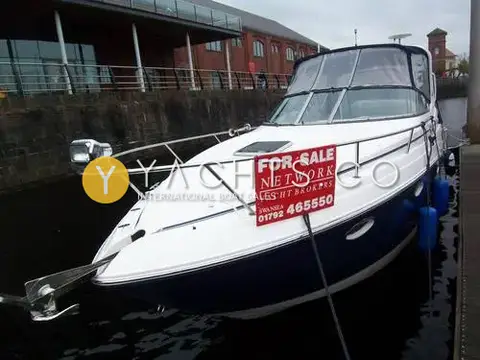 Rinker 280 Express Cruiser: bow view moored alongside a pontoon, with bow spotlight, anchor and a for sale board