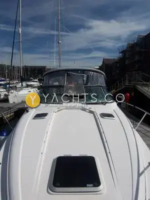 Rinker 330: foredeck from the bow looking aft to the windscreen, with hatch and marina behind