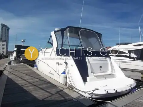 Rinker 330: starboard quarter afloat on a pontoon, navy canopy fitted over the cockpit