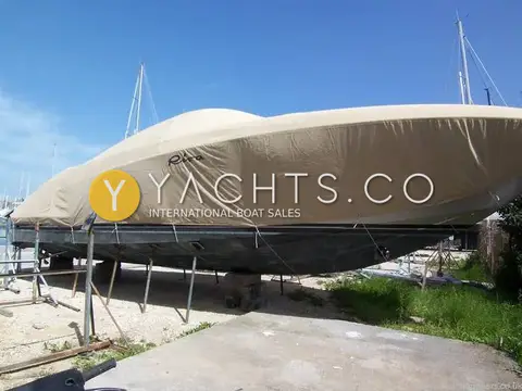 Riva Rivarama 44: hull ashore on stands under a full beige fitted cover with Riva logo