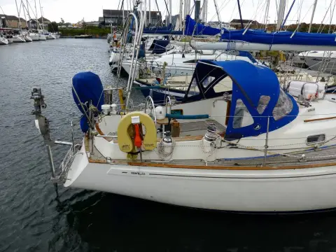 Rival 36: stern quarter with horseshoe lifebuoy, wind vane bracket and blue sprayhood