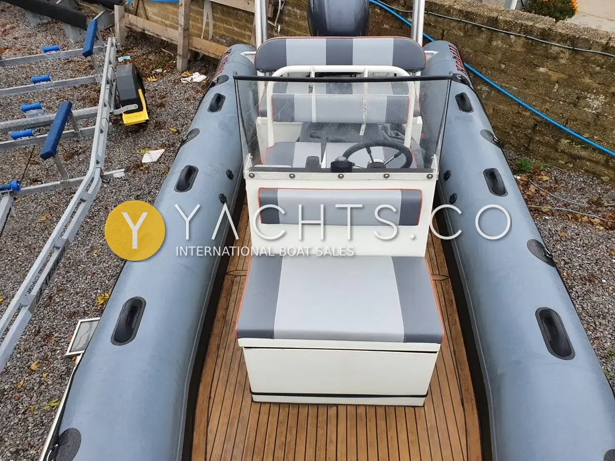 Robust Alimal 570C: view aft over grey tubes to console, helm seat and teak-effect deck