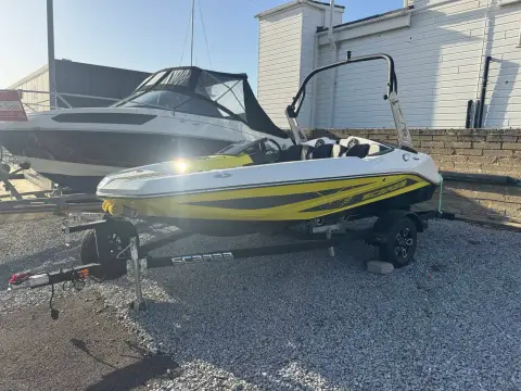 Scarab 165: bow quarter view on gravel showing trailer drawbar and yellow and black hull graphics