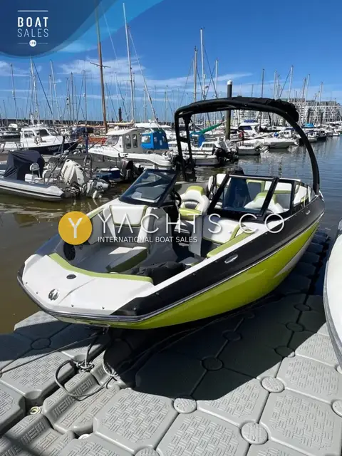 Scarab 195 ID: bow view showing open bow seating, split windscreen and black wakeboard tower in a marina