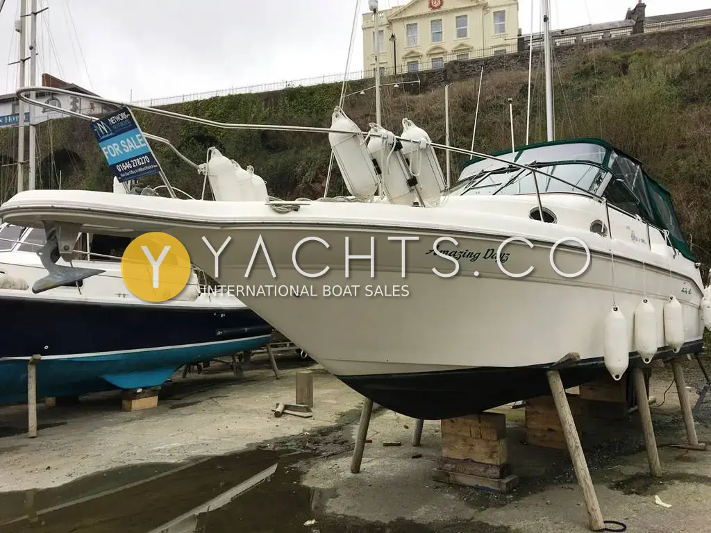 Sea Ray Sundancer 270: starboard bow view of the white hull ashore on stands, with fenders racked on the bow rail