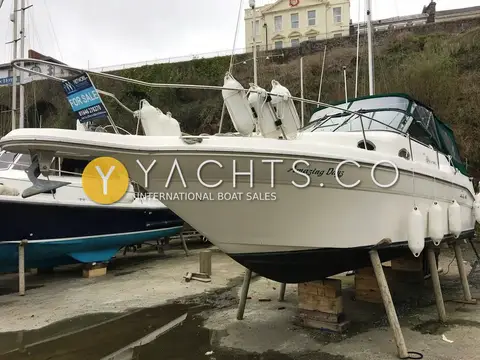 Sea Ray Sundancer 270: starboard bow ashore on stands in the boatyard, green canopy fitted and anchor on the bow