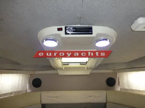 Sealine International 285: saloon roof console with two lights and radio beside the opening roof hatch