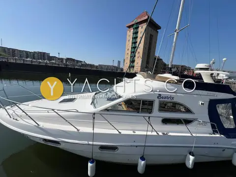 Sealine International 330 Statesman: port side profile with flybridge rails, moored in a marina under a blue sky